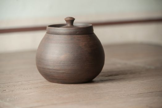 Traditional handcrafted brown pot with a cap