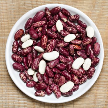 Beans in a bowl, on a background of old wood surface.