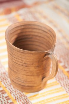 Traditional handcrafted mug on the multycolor background