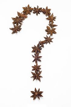 Question mark made of star anise isolated on white background