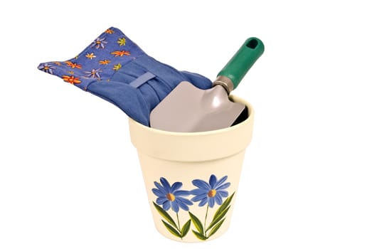 Vertical shot of a pretty flower pot with gloves and trowel.  Isolated on white.