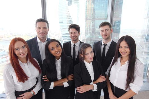 Portrait of business team of men and women in office with view on skyscrapers