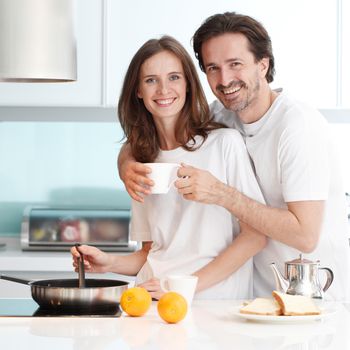 Happy couple cooking breakfast together in the kitchen