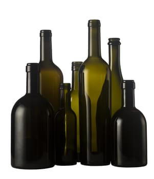 Horizontal front view of a group of empty wine bottles of different sizes, shapes and colorisolated on white background.