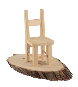Wooden chair sitting on a slice of wood isolated on white background