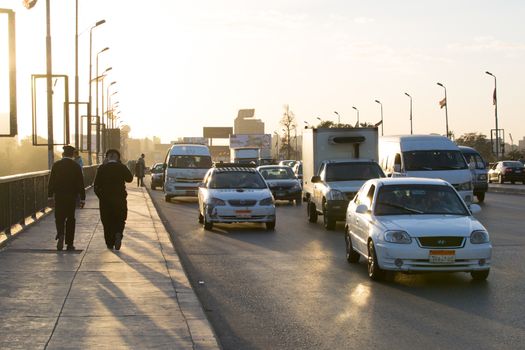 Cairo, Egypt - March 4, 2016: Egyptian policemen walking on the 6th October bridge in central Cairo at dusk