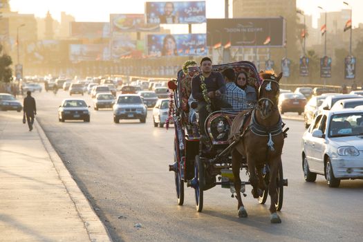 Cairo, Egypt - March 4, 2016: Horse carriage on the 6th October bridge in central Cairo at dusk.