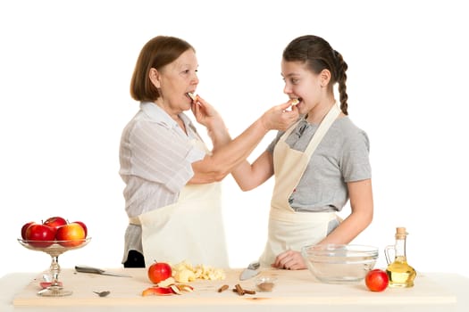 the grandmother and the granddaughter treat each other with apple pieces on a white background