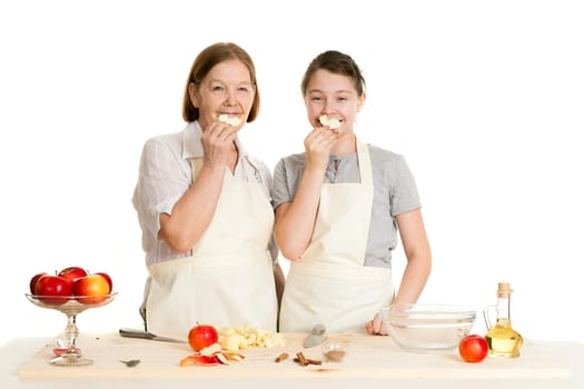 the grandmother and the granddaughter hold apple pieces at the person on a white background