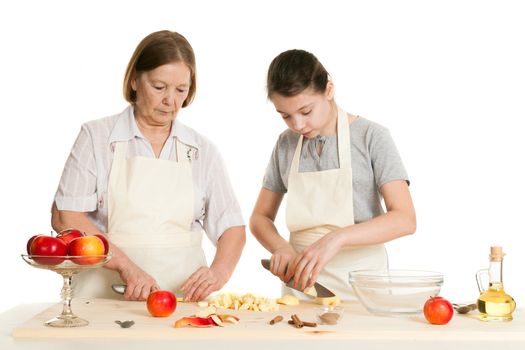 the grandmother teaches the granddaughter to knife apples on a white background