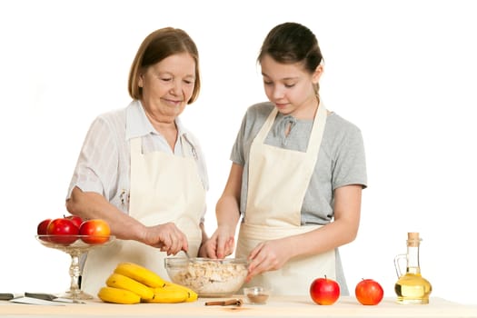 the grandmother and the granddaughter stir ingredients in a bowl on a white background