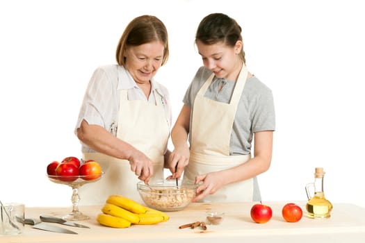 the grandmother and the granddaughter stir ingredients in a bowl on a white background