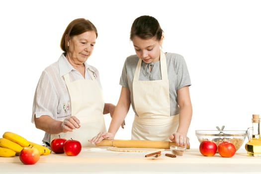 the grandmother and the granddaughter roll dough with a rolling pin for pie on a white background