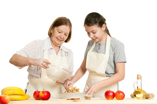 the grandmother and the granddaughter stack a stuffing in a form for pie