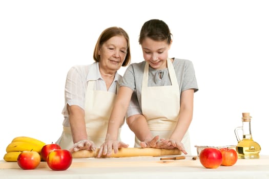 the grandmother and the granddaughter roll dough with a rolling pin for pie on a white background