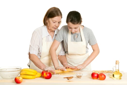 the grandmother and the granddaughter roll dough with a rolling pin for pie on a white background