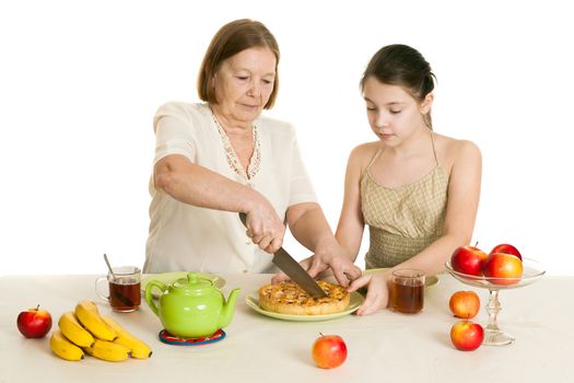 the grandmother treats the granddaughter with pie at a table