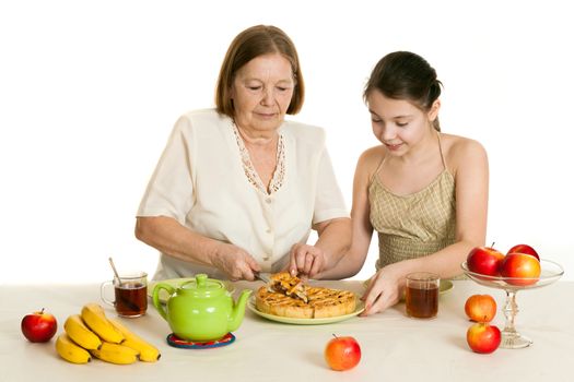 the grandmother treats the granddaughter with pie at a table