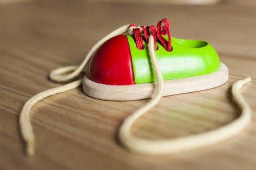 Ornamental shoe toy made of wood with shoelaces
