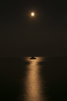 Small boat under the moon reflection. Full moon.