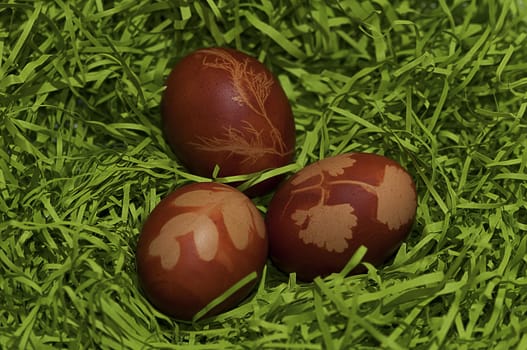 Red easter eggs with models on paper grass