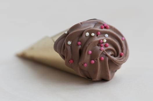 Closeup of a chocolate cone isolated on a wooden table