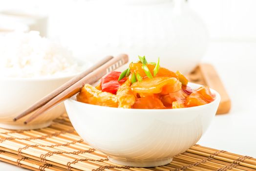 Bowl of sweet and sour chicken photographed closeup.  Useful for menus and other food service promotions.