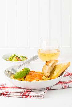 Totrtelloni and rose sauce served with caesar salad and wine.  Useful for menus and other food service promotional materials.
