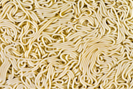 Cooked spaghetti background conceptual of a puzzle, maze or interconnected complicated convoluted network in an overhead full frame view of a flattened layer of noodles