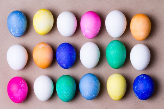 Neat arrangement of colorful dyed Easter eggs in three rows in a festive holiday background for celebrating a traditional Easter