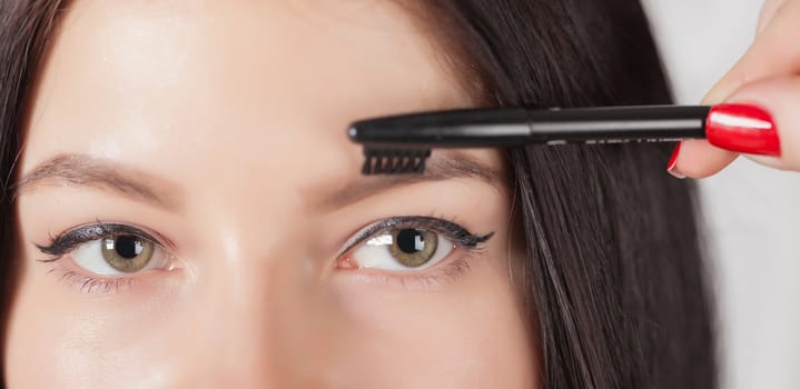 young woman doing her makeup, eyes closeup