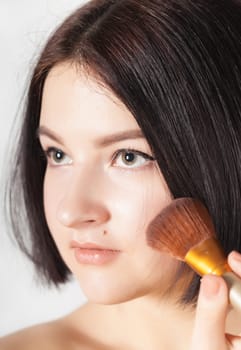 the girl does make-up on a light background