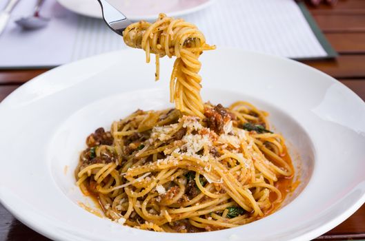 Spaghetti noodles with meat sauce on white plate.