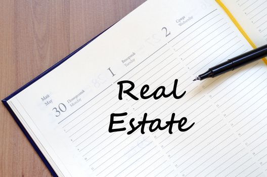 Real estate text concept write on notebook with pen