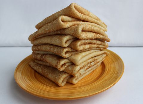 Pancakes with butter on a plate, as a symbol of ancient Slavic celebration of Carnival. Meet spring, winter farewell.