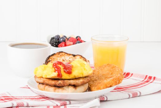 Breakfast sandwich served with fresh fruit coffee and juice.