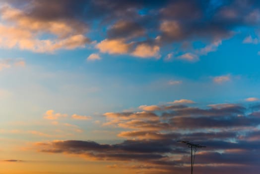 Antenna under sunset sky cathing waves.