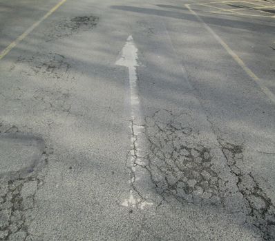 Roadway diectional arrow on a tarmac background