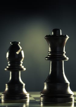Vertical image of a chess game with focus on the queen over dark background, Concept of management or business anticipation.