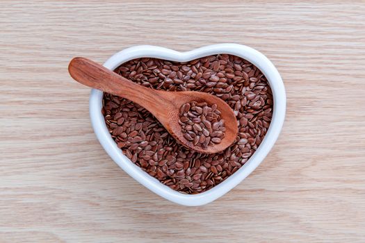 Alternative health care and dieting flax seeds in wooden spoon set up on rustic wooden background.