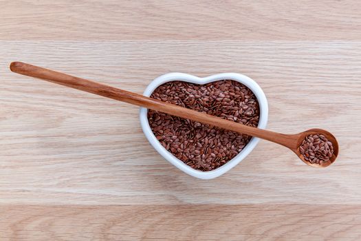 Alternative health care and dieting flax seeds in wooden spoon set up on rustic wooden background.