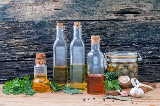 Different sorts of cooking oil,olive oil flavored and Sesame oil with spices herb rosemary ,thyme,dill,sage and parsley set up with old wooden background.