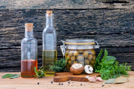 Different sorts of cooking oil,olive oil flavored and Sesame oil with spices herb rosemary ,thyme,dill,sage and parsley set up with old wooden background.