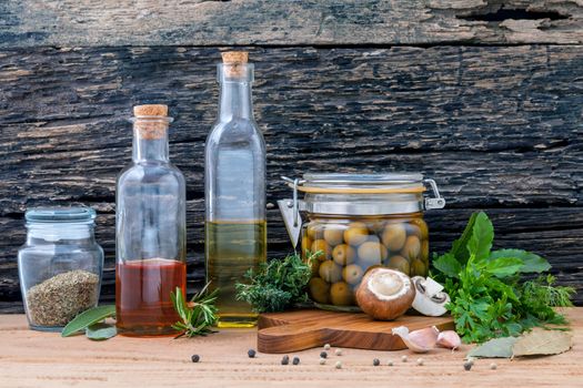 Different sorts of cooking oil,olive oil flavored and Sesame oil with spices herb rosemary ,thyme,dill,sage and parsley set up with old wooden background.