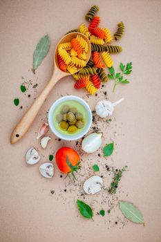 Italian food concept pasta with vegetables olive oil flavored with spices herb rosemary ,thyme,parsley and champignon mushroom set up with brown background.