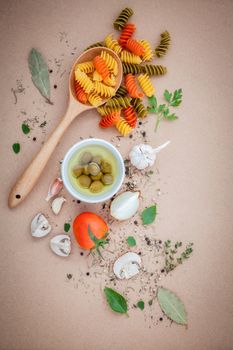 Italian food concept pasta with vegetables olive oil flavored with spices herb rosemary ,thyme,parsley and champignon mushroom set up with brown background.