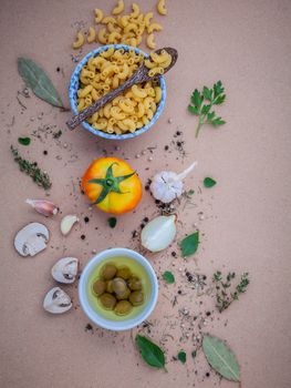 Italian food concept pasta with vegetables olive oil flavored with spices herb rosemary ,thyme,parsley and champignon mushroom set up with brown background.