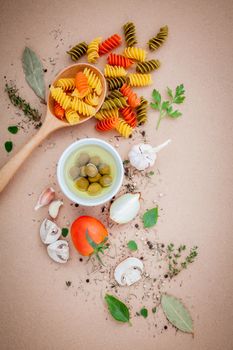 Italian food concept pasta with vegetables olive oil flavored with spices herb rosemary ,thyme,parsley and champignon mushroom set up with brown background.