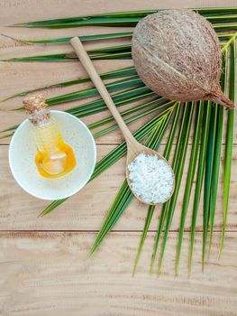 Coconut oil , coconut powder and coconut on coconut leaves set up on brown wooden background for alternative therapy.