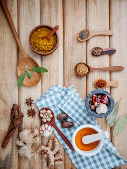 Food Cooking ingredients. Dried Spices herb cinnamon sticks,bay leaves,ginger,turmeric,nutmeg,chili,black pepper,fennel and saffron with the mortar on rustic wooden background.